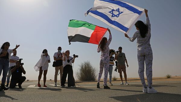 İsrail bayrağını omzunda taşıyarak Dubai'nin çöl bölgelerinde poz veren Tager'e, burada ikamet eden Rus Anastasia Bandarenka de BAE bayrağı ile eşlik etti.  - Sputnik Türkiye