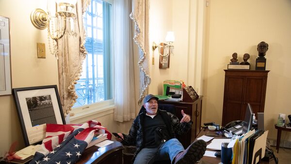 Trump destekçilerinden Richard Barnett, Temsilciler Meclisi Başkanı Nancy Pelosi'nin ofisinde oturuyor. - Sputnik Türkiye