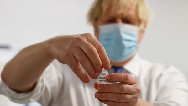 Biontech-Pfizer ve Oxford-AstraZeneca aşılarının kullanıldığı merkezde elinde aşı tutan Boris Johnson  - Sputnik Türkiye
