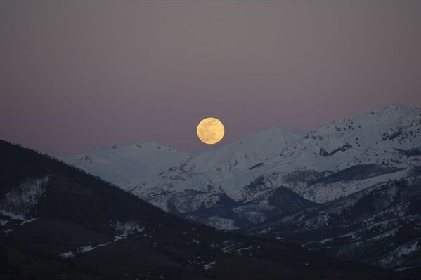 Tunceli'de akşam saatlerinde beliren dolunay, karla kaplı Munzur Dağları ile güzel görüntü oluşturdu. - Sputnik Türkiye