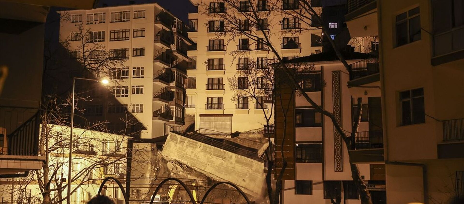 Ankara'nın Çankaya ilçesine bağlı İleri Mahallesi Mektep Sokak'ta yakın zamanda yapımına başlanan inşaat çalışmaları sırasında yan tarafında bulunan Altay Sokak'taki 8 katlı binanın istinat duvarının yıkılması ve temelinde boşluk oluşmasıyla çökme tehlikesi meydana geldi. - Sputnik Türkiye, 1920, 10.04.2021