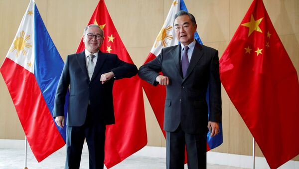 Filipinler Dışişleri Bakanı Teodoro Locsin ile Çin Dışişleri Bakanı Wang Yi, Manila'daki görüşmede dirsek selamı verirken - Sputnik Türkiye