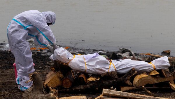 Kovid-19'dan ölen yakınıyla Ganj Nehri kıyısında yakılmasından önce koruyucu kıyafetler giyerek vedalaşan Hindistanlı (Uttar Pradeş, Garhmukteshwar) - Sputnik Türkiye