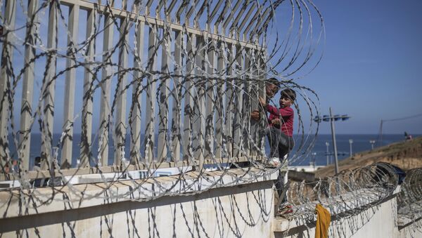 Мигранты перелезают через забор на границе Марокко и Испании, недалеко от испанского анклава Сеута - Sputnik Türkiye