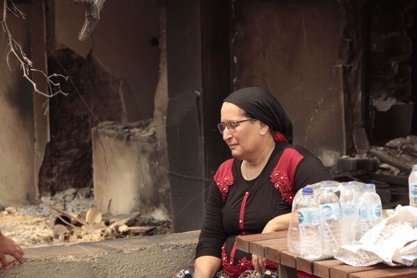 Kalemler Mahallesi’nde vatandaşlar yanan evlerin önünde oturarak yardımları bekledi. - Sputnik Türkiye
