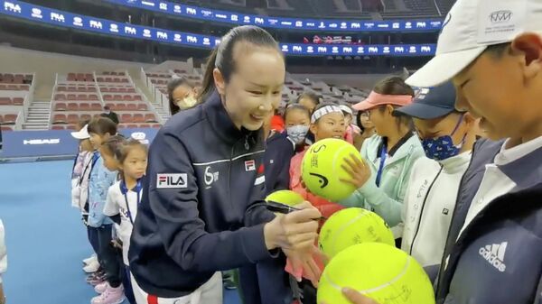 Çin'de ortadan kaybolduktan 19 gün sonra insanların içine çıkan tenis yıldızı Peng Shuai, Pekin'de Fila Alt YaşTenis Challenger Finali'nde büyük tenis toplarını imzalarken (Çin, Pekin, 21 Kasım 2021) - Sputnik Türkiye