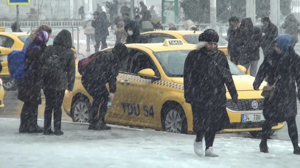 İstanbul'da Taksim Meydanı'nda yoğun kar yağışı altında taksi taksi dolaşanlar, taksimetre açmayıp yüksek fiyat isteyen bazı sürücüler nedeniyle kar altında beklemek zorunda kaldı. - Sputnik Türkiye