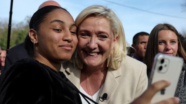 Fransa'da cumhurbaşkanlığı seçiminin ilk turunun ertesinde ikinci tur için Soucy'de kampanya yürüten Ulusal Birlik Partisi (RN) lideri Marine Le Pen, taraftarlarıyla selfie çektirirken - Sputnik Türkiye