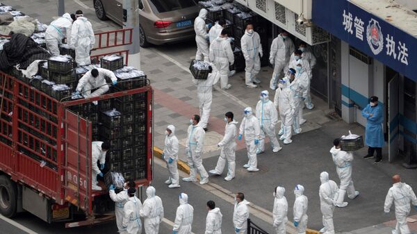 Çin'in 28 Mart 2022'de kapanmaya giden en büyük şehri Şanghay'da koronavirüse karşı korunaklı kıyafetler içinde günlük gıda ve diğer temel ihtiyaç maddesi tedarikini dağıtan çalışanlar (5 Nisan 2022) - Sputnik Türkiye