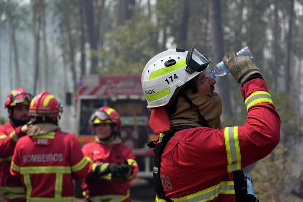 Portekiz'de yangınlarla mücadele eden itfaiyecilerden biri gözlerini suyla yıkıyor. Ülkede çıkan orman yangınları, onlarca kişilerin tahliyesine neden oldu. - Sputnik Türkiye
