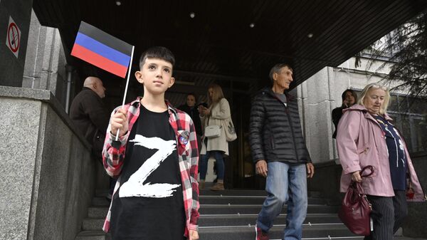 Donetsk Halk Cumhuriyeti'nde ailesiyle birlikte referanduma giden çocuk - Sputnik Türkiye
