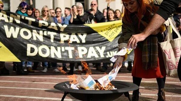 Britanya'da 'Don't Pay UK' (Ödeme Yapma Birleşik Krallık) kampanyasının ülke çapında düzenlediği protesto gösterilerinde yoğun katılım eşliğinde enerji faturaları yakıldı. - Sputnik Türkiye