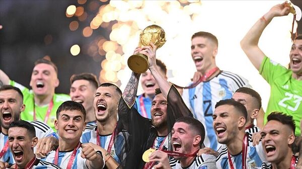 Katar Emiri Şeyh Temim bin Hamed el Sani'nin giydirdiği bişt denilen cübbeyle Dünya Kupa'sını kaldıran Lionel Messi'nin etrafında zafer kutlaması yapan Arjantin milli takımı  - Sputnik Türkiye