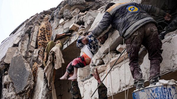 Жители извлекают ребенка из-под обломков разрушенного здания после землетрясения в городе Джандарис на северо-западе Сирии - Sputnik Türkiye