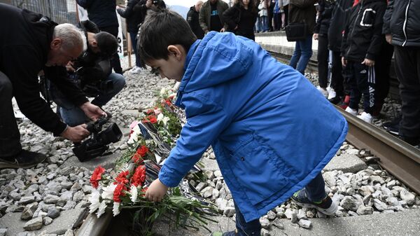 Yunanistan yurttaşları, Larisa kentinin kuzeyindeki Tempi bölgesinde yolcu treni ile yük treninin çarpıştığı kaza yerinde rayların üzerine kurbanların anısına çiçek bırakırken - Sputnik Türkiye