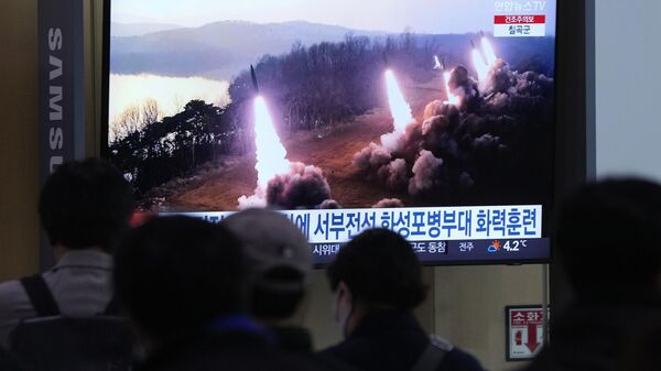 Kuzey Kore'nin Güney'in askeri havaalanını vurma simülasyonlu topçu tatbikatı ve 6 kısa menzilli balistik füze denemesinin görüntülerini Seul'de bir tren istasyonundaki ekrandan izleyen Güney Koreliler  - Sputnik Türkiye