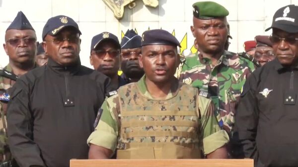 Bu sabah askerin yönetime el koyduğu Gabon'da geçiş hükümetinin liderliğine Cumhuriyet Muhafızları Komutanı General Brice Oligui Nguema getirildi. Devlet televizyonunda Albay Ulrich Manfoumbi (ortada) tarafından okunan bildiride, geçiş hükümetinin başına oy birliğiyle General Nguema'nın getirildiği duyuruldu. - Sputnik Türkiye