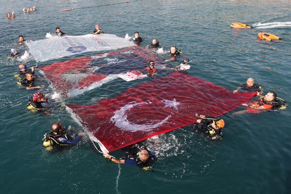 Dalışın  ardından denizde Türk bayrağı da açan Ercümen, Türkiye Cumhuriyeti'nin  kuruluşunun 100. yılını kutladı. - Sputnik Türkiye