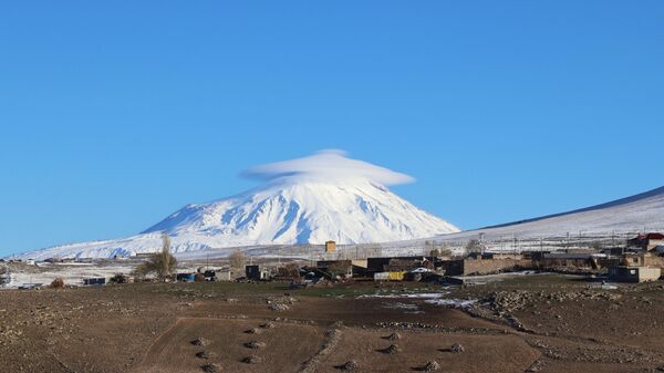Türkiye'nin en yüksek noktası Ağrı Dağı'nın karlı zirvesini kaplayan şapka şeklinde mercek bulut oluştu. - Sputnik Türkiye
