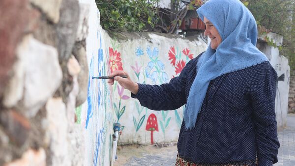 İzmir’in Çeşme ilçesinin tek Türkmen köyü olan Germiyan köyünde yaşayan 61 yaşındaki Nuran Erden, duvarlara ve elektrik direklerine  çizdiği resimlerle köyünün turizmle  buluşmasına katkı sağladı.  - Sputnik Türkiye