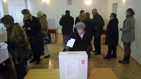 A woman casts her ballot at a polling station during the presidential election in Zagreb - Sputnik Türkiye