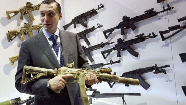 Aleksey Krivoruchko, chief executive of Russian firearms maker Kalashnikov Concern, holds a weapon during the International Defence Exhibition (IDEX) in Abu Dhabi February 22, 2015 - Sputnik Türkiye