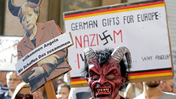 Merkel'i protesto edenler ellerinde 'Almanya'nın Avrupa'ya hediyesi Nazizm ve İslam' ile 'Hoşgeldin Angela, birlikte başarabiliriz' yazılı pankartlar taşıdı. - Sputnik Türkiye