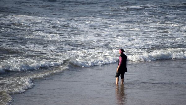 A Moroccan woman wearing a burkini, a full-body swimsuit designed for Muslim women, enters the sea at Oued Charrat beach, near the capital Rabat - Sputnik Türkiye