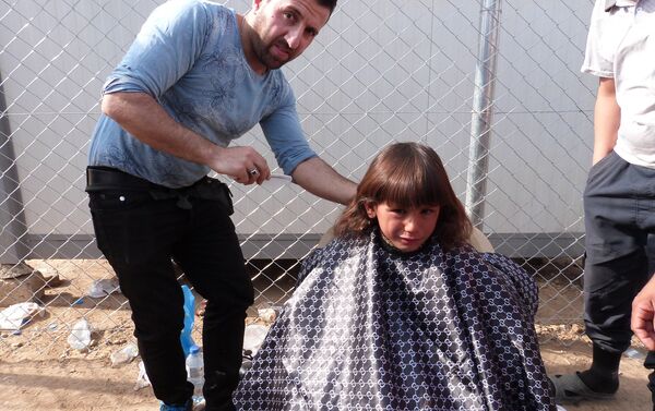 Musul'daki savaştan kaçan çocuklardan biri mülteci kampında saçını kestiriyor. - Sputnik Türkiye