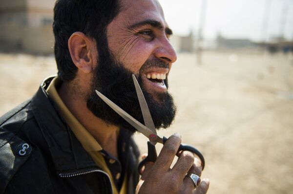 Musul'un banliyösünde hükümet güçlerinin yanına giden Iraklı adam sakalını kesiyor. - Sputnik Türkiye
