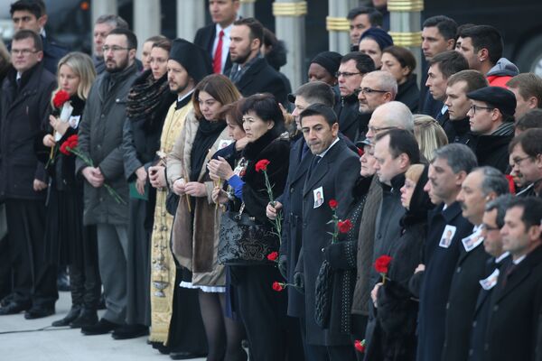 Törende Karlov'un ailesi ve ona yakın olanların ellerinde kırmızı güller taşıdığı görüldü. - Sputnik Türkiye