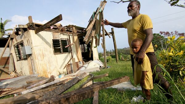 Tailevu bölgesinde Winston kasırgasının yıktığı evinin önünde poz veren bir Fijili - Sputnik Türkiye