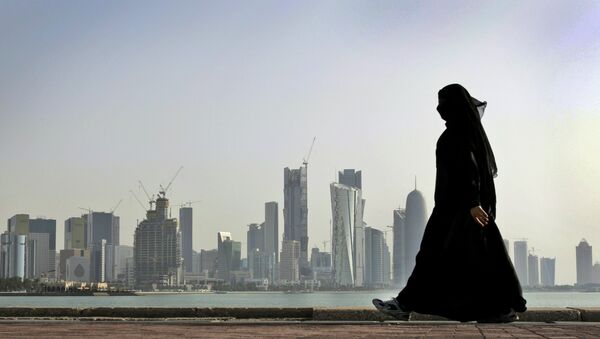 A Qatari woman walks in front of the city skyline in Doha, Qatar. - Sputnik Türkiye