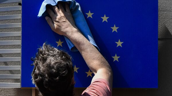 A worker wipes an EU flag clean. - Sputnik Türkiye