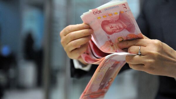 A bank employee counts 100-yuan banknotes at a bank in Hangzhou, east China's Zhejiang province on December 1, 2015. - Sputnik Türkiye
