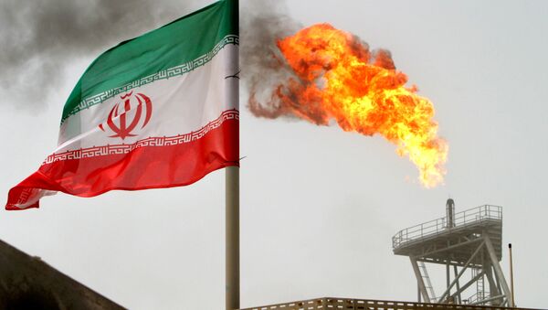 A gas flare on an oil production platform in the Soroush oil fields is seen alongside an Iranian flag in the Persian Gulf, Iran, July 25, 2005 - Sputnik Türkiye