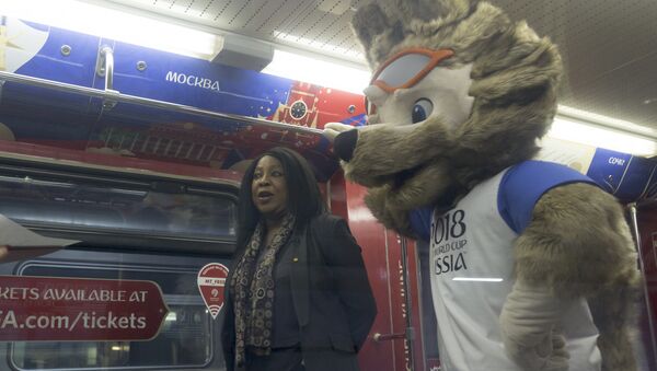 Fatma Samoura, FIFA Secretary General, left, speaks to the media with a mascot of the 2018 World Cup, the wolf named Zabivaka, seen at right, in the metro train branded for the 2018 World Cup during a ceremony in Moscow, Russia, on Tuesday, Nov. 28, 2017 - Sputnik Türkiye