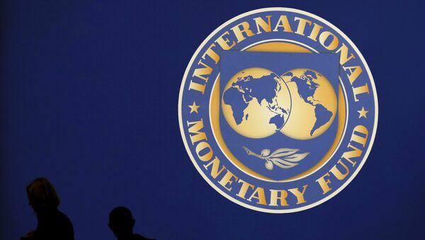 Visitors are silhouetted against the logo of the International Monetary Fund at the main venue for the IMF and World Bank annual meeting in Tokyo in this October 10, 2012 file photo. - Sputnik Türkiye