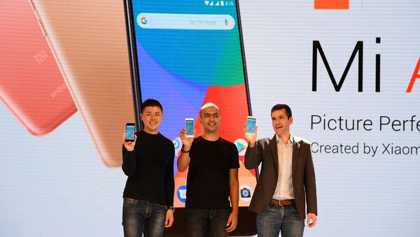 (L-R) Donovan Sung, director of product management and marketing at Xiaomi Global, Manu Jain, managing director of Xiaomi India, and global director of Android Partner Programs Jon Gold hold the newly launched Xiaomi Mi A1 smartphone at a function in New Delhi on September 5, 2017 - Sputnik Türkiye