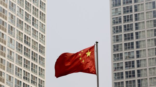 A Chinese national flag flutters in the wind in between a high-rise residential and office complex in Beijing, China. (File) - Sputnik Türkiye