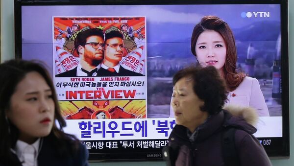People walk past a TV screen showing a poster of Sony Picture's The Interview in a news report, at the Seoul Railway Station in Seoul, South Korea, Monday, Dec. 22, 2014 - Sputnik Türkiye