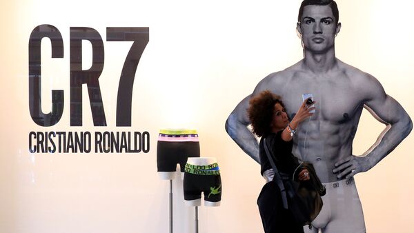 Bu sezon Real Madrid'den Juventus'a transfer olan Cristiano Ronaldo'nun çamaşır reklamının bulunduğu Milano'daki pano önünde bir kadın selfie çekiyor. - Sputnik Türkiye
