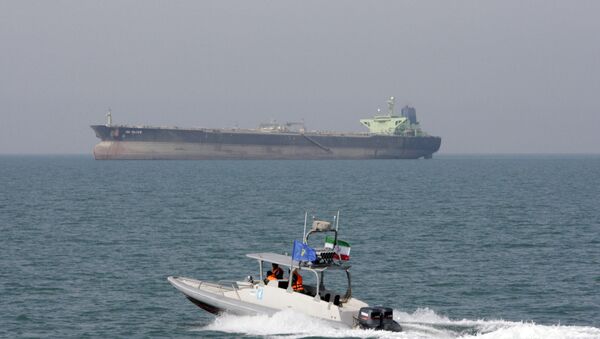 In this July 2, 2012 file photo, an Iranian Revolutionary Guard speedboat moves in the Persian Gulf while an oil tanker is seen in background - Sputnik Türkiye