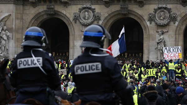 15 Aralık'ta Paris'teki Opera binası önünde atlı polislerin kuşattığı Sarı Yelekler'den biri, Fransa Cumhurbaşkanı Emmanuel Macron'a hitaben Defol git yazılı dövizi havaya kaldırmış halde görülüyor. - Sputnik Türkiye