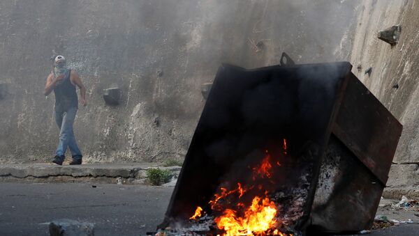 Caracas'ta isyan girişiminde bulunan askeri birliğe yakın Cotiza mahallesinde yaşayanlar tencere tava çalıp çöp konteynerlerini ateşe verdi ve güvenlik güçlerine taş attı. - Sputnik Türkiye