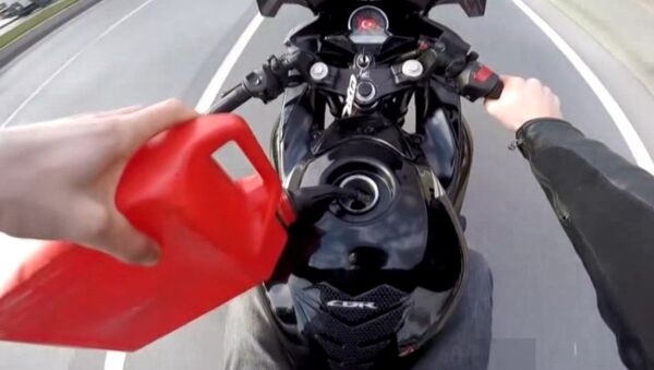 seyir halinde deposuna benzin dolduran motosiklet sürücüsü - Sputnik Türkiye