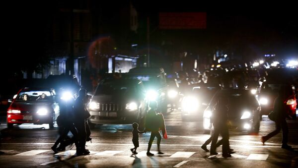 Residents cross a street in the dark after a power outage in Caracas, Venezuela, Thursday, March 7, 2019. A power outage left much of Venezuela in the dark early Thursday evening in what appeared to be one of the largest blackouts yet in a country where power failures have become increasingly common. Crowds of commuters in capital city Caracas were walking home after metro service ground to a halt and traffic snarled as cars struggled to navigate intersections where stoplights were out. - Sputnik Türkiye