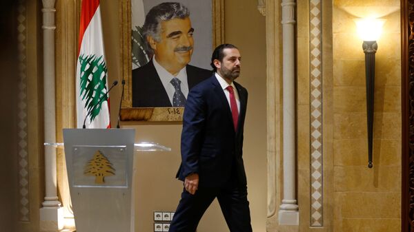 Suikasta kurban giden babası Refik Hariri'nin portresi önünde başbakanlıktan istifasını sunacağını açıklayan Saad Hariri, salondan çıkarken - Sputnik Türkiye