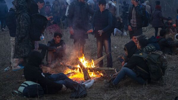 Geceyi burada geçiren sığınmacılar yaktıkları ateşin etrafında ısınmaya çalıştı. - Sputnik Türkiye