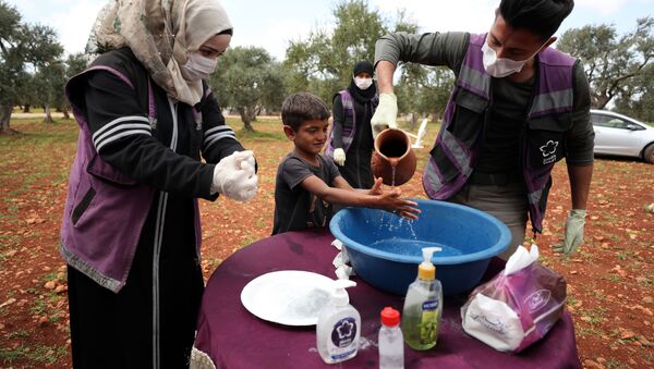 Suriye-Gönüllüler, koronavirüs tedbirleri kapsamında mültecilere ellerini nasıl yıkayacağını öğretiyor. - Sputnik Türkiye